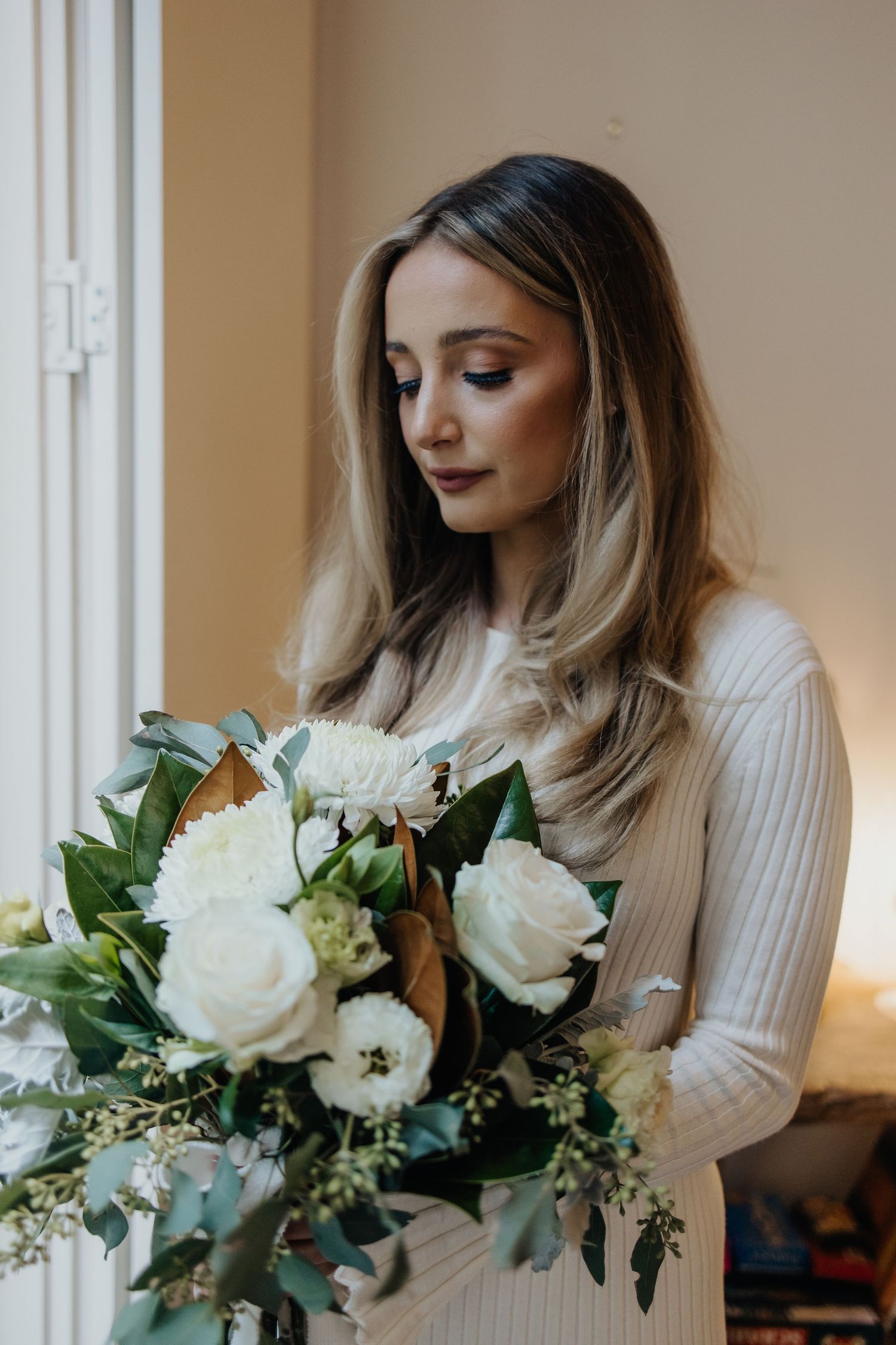 Elegant white roses and greenery in a bridal bouquet arrangement.