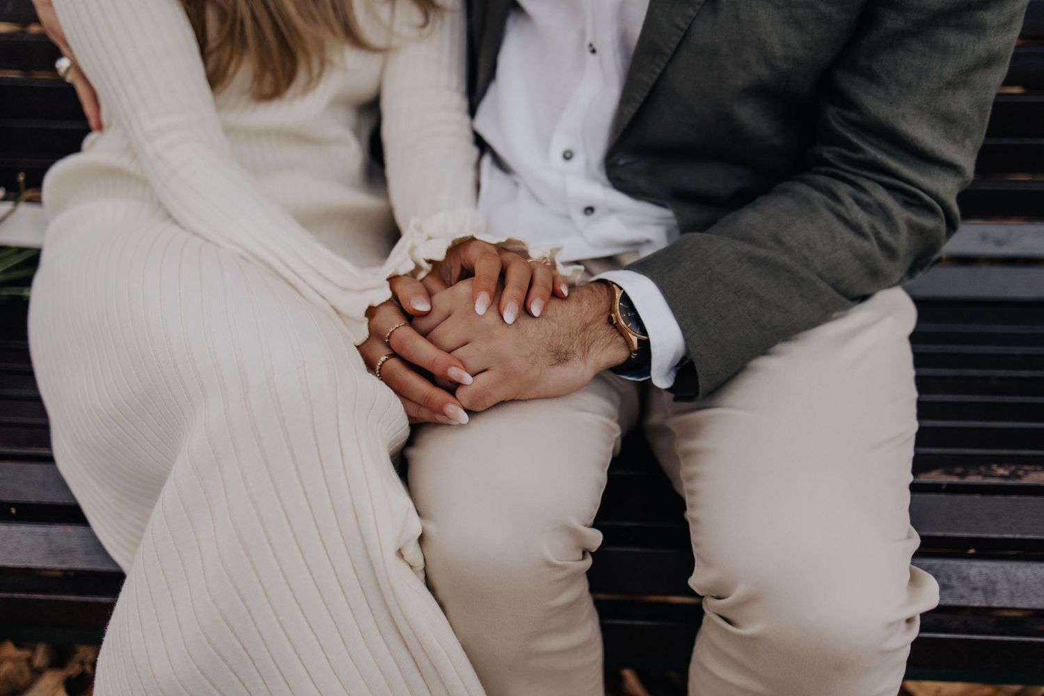 Close-up of couple sharing intimate moment on park bench in formal attire.
