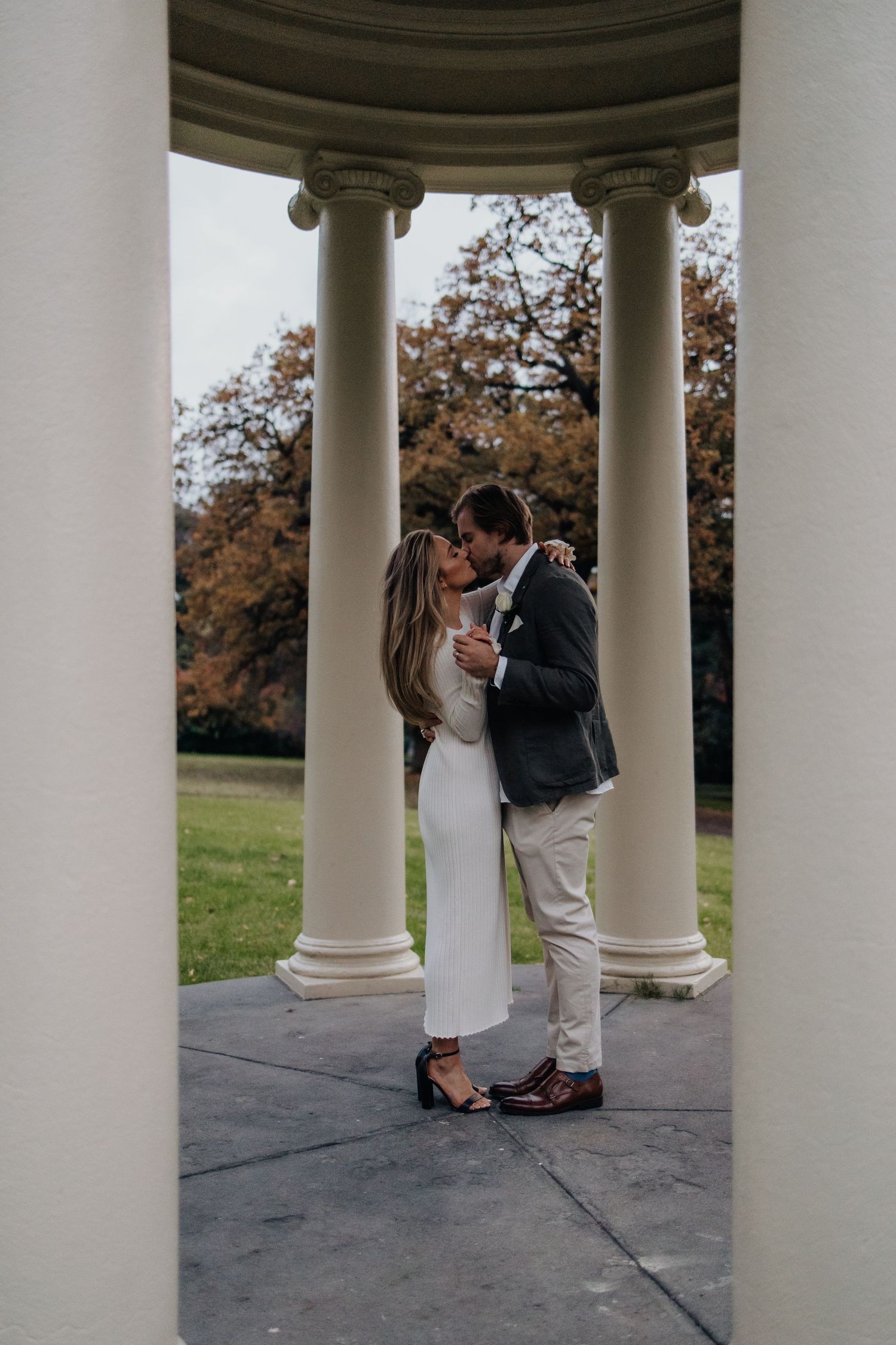 Elegant wedding photos captured under classical white columned rotunda.