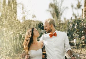 A wedding couple shares an intimate moment in a garden setting.