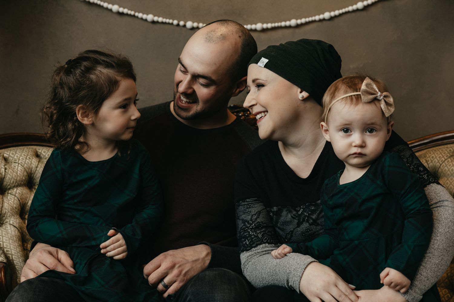 Intimate family lifestyle session showing candid moments on a dark couch.