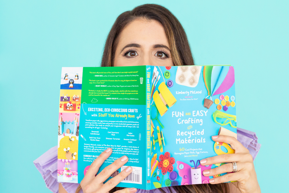 Colorful educational or planning materials being held up against blue background.