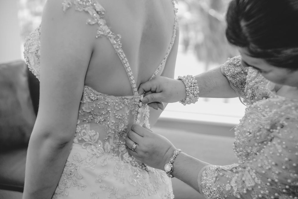 mother closing up bride's dress. mother and daughter at getting ready. cambria hotel. McAllen, Texas. Wedding photograph
