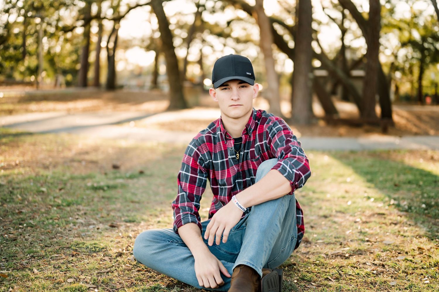 Casual outdoor portrait session in a natural park setting with autumn leaves.