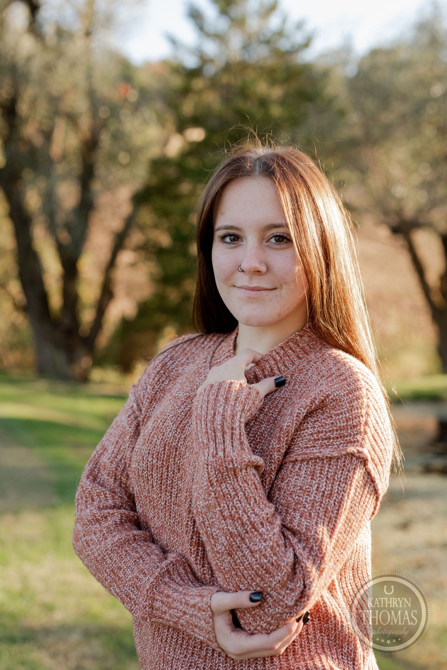 Casual outdoor portrait featuring a cozy pink knit sweater against an autumn backdrop.