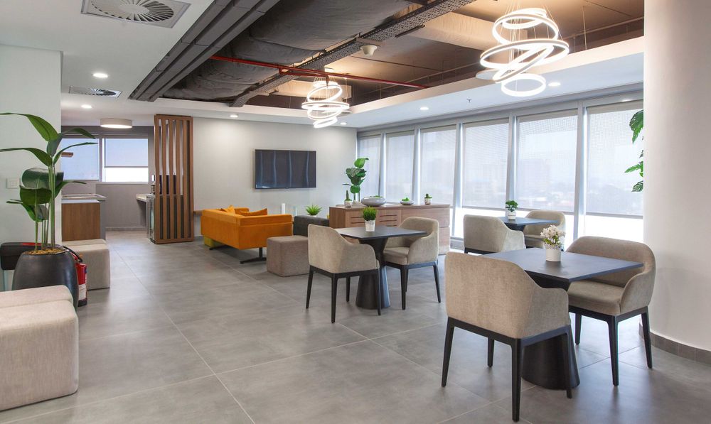 Corporate meeting space with elegant pendant lighting, comfortable seating, and large windows for natural light.