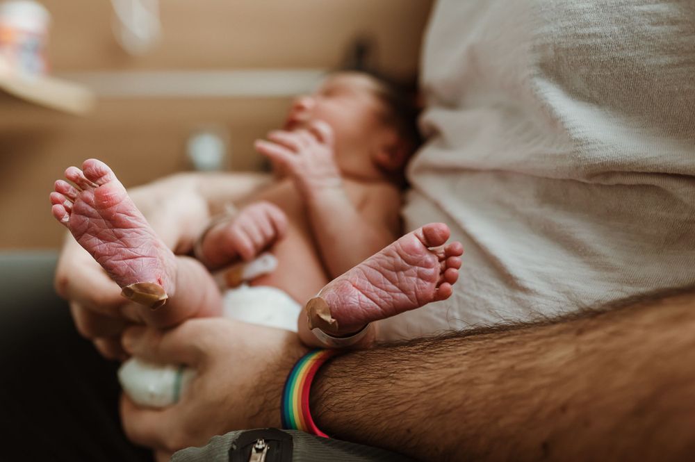newborn feet with bandaids on the heel