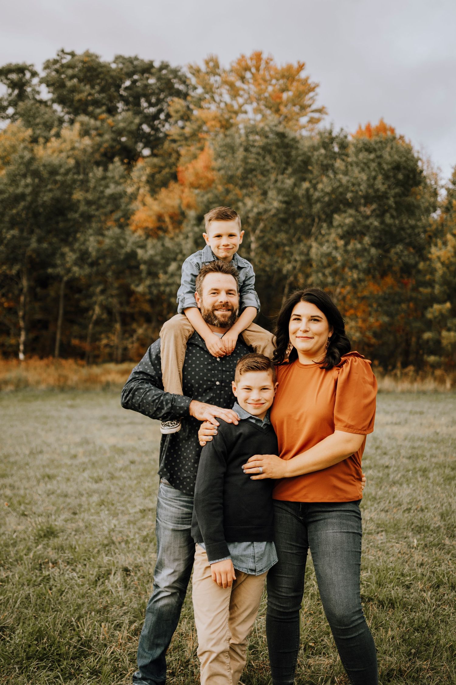 A happy family enjoying a playful moment together during their fall photo session.