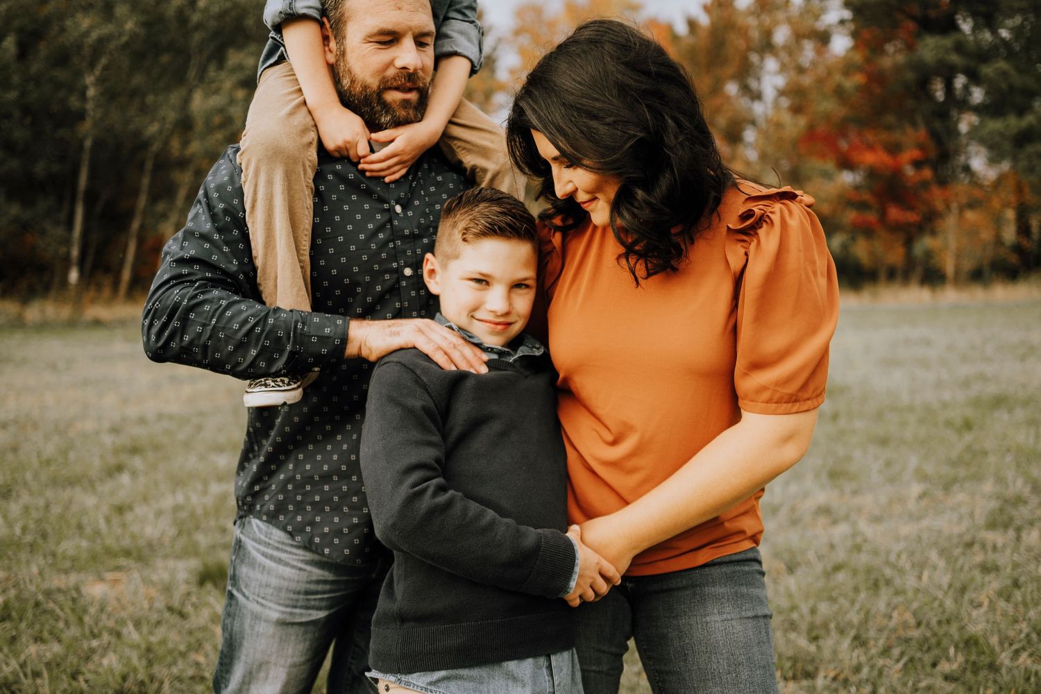 A close-knit family shares a tender moment during their autumn photo session.
