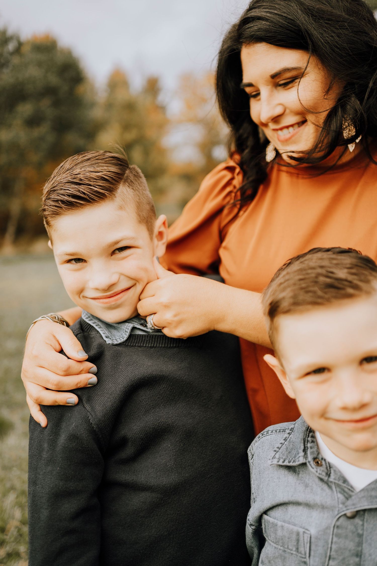 Close-up shot of family members smiling and embracing during fall photo session.