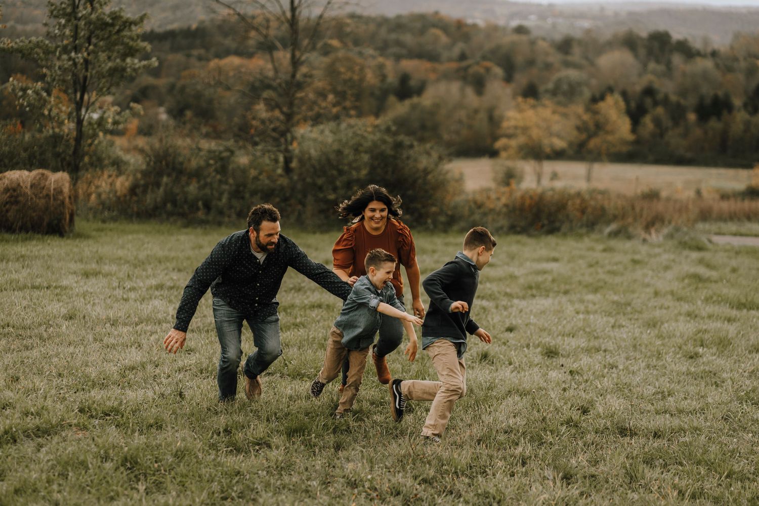 Playful running scene of a family enjoying time together in an open field.
