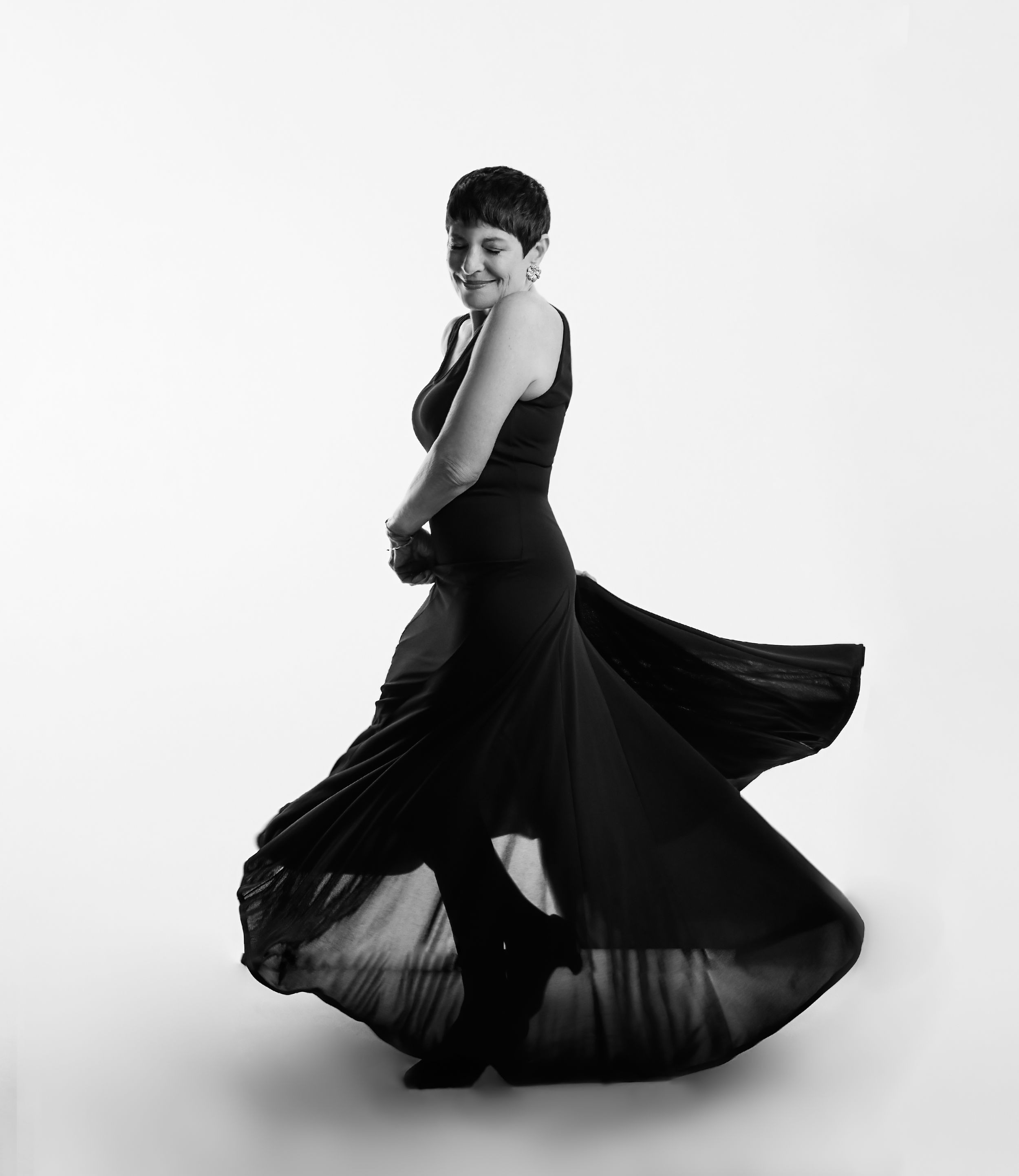 Artistic black and white series showing dancer in flowing dress creating dynamic movement.