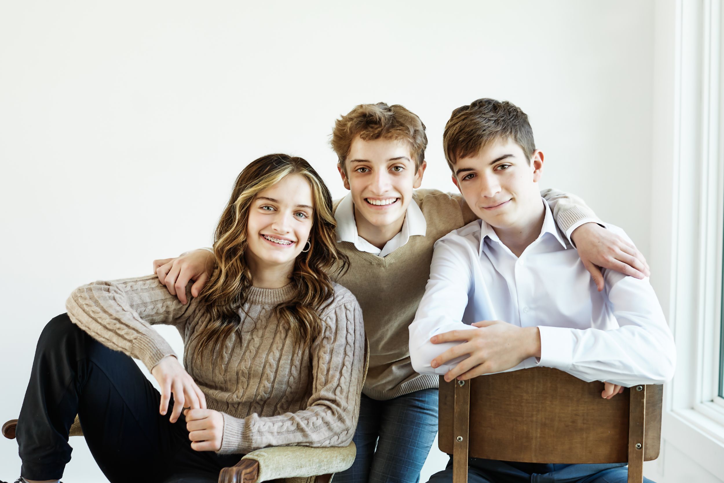 Family portrait series showing casual group poses in white studio setting.
