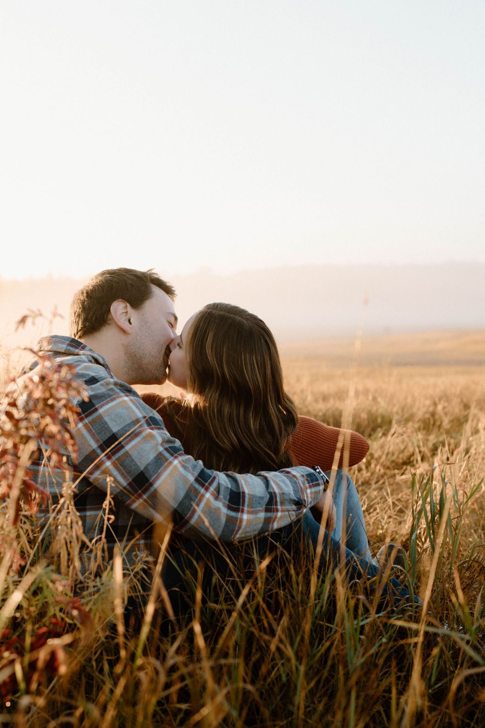 Romantic moment captured in golden wheat field during sunset.