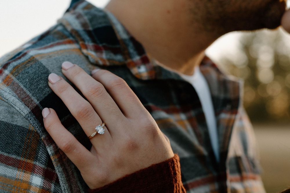 Close up of hands during an intimate moment between a couple outdoors.