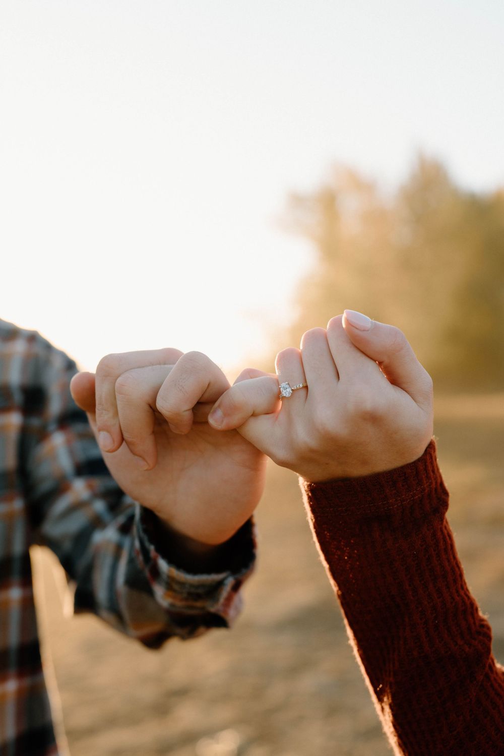 Close-up of pinky promise between two hands at golden hour.