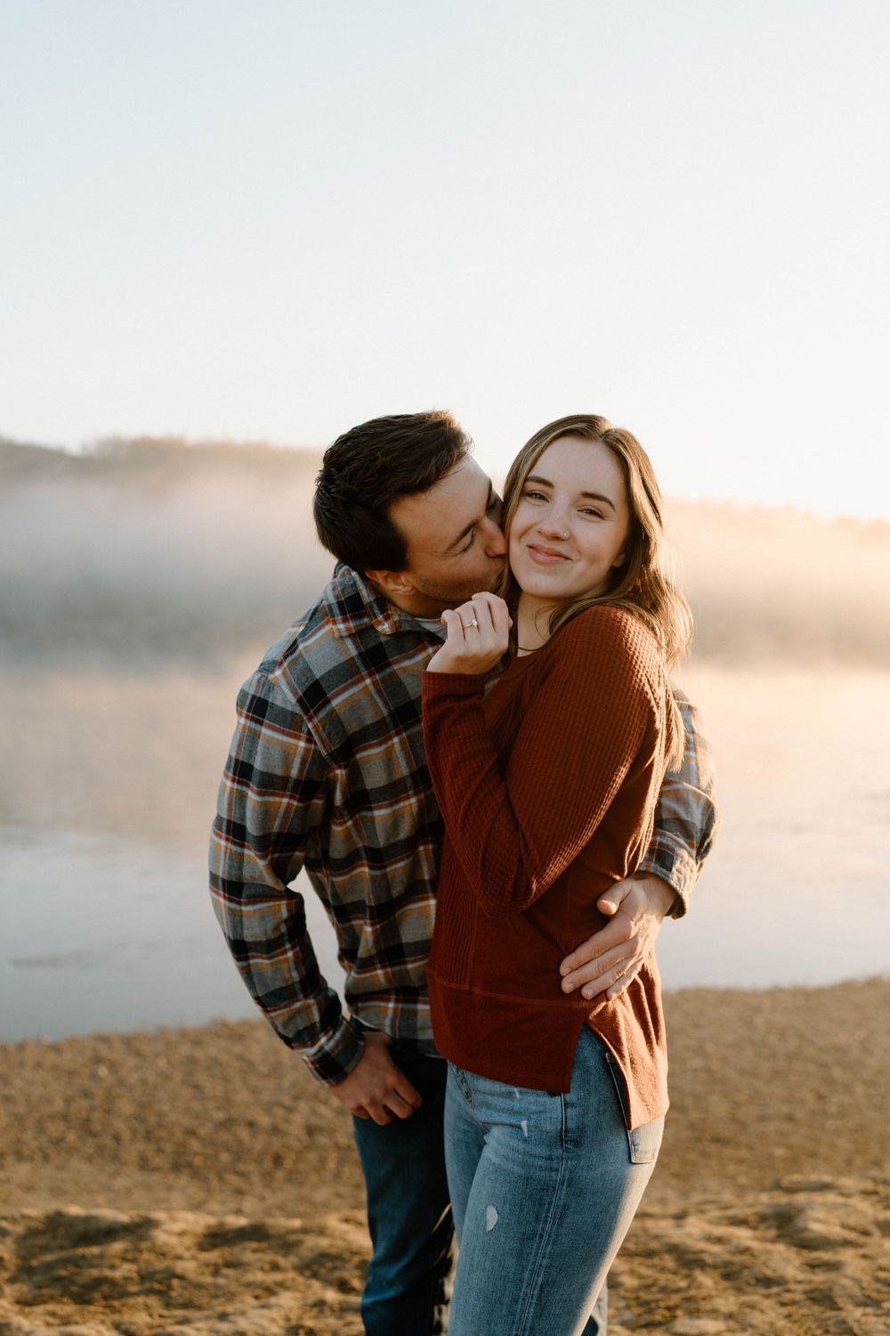 A sweet candid moment shared between two people in casual attire outdoors.