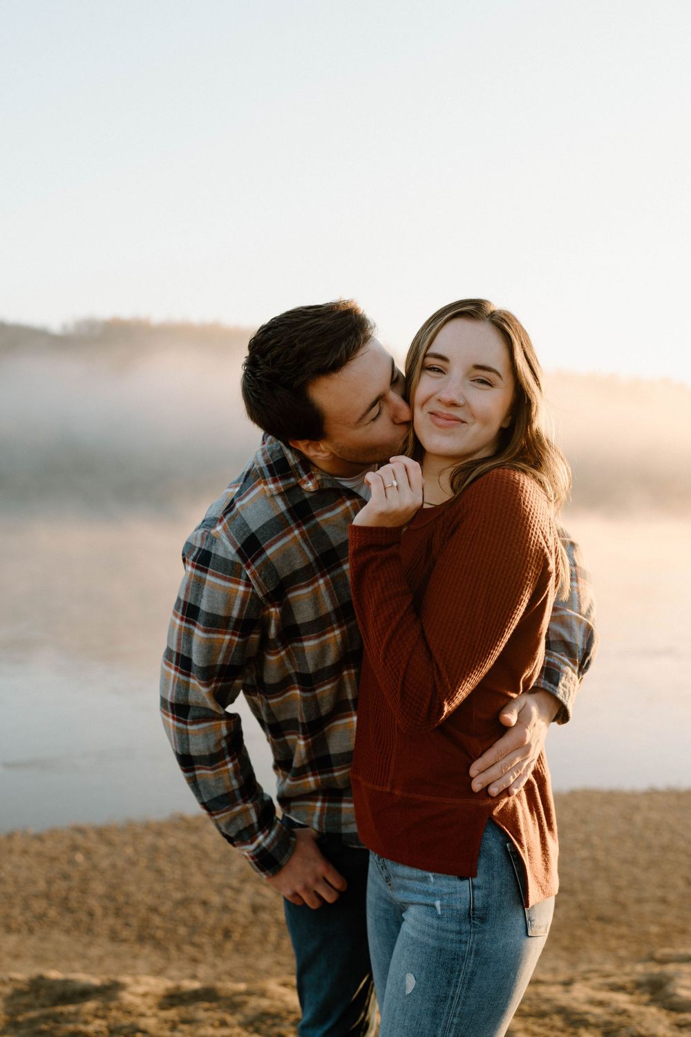 A tender moment between two people captured against a bright outdoor setting.