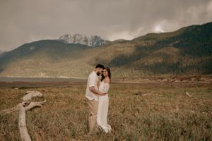 Intimate moment captured against dramatic mountain landscape on overcast day.