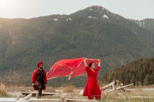 Dynamic scene with flowing red fabric against snowy mountain backdrop.