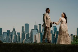 Elegant couple poses against Chicago skyline backdrop in formal attire.