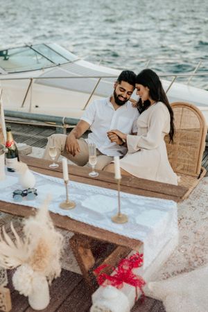 Romantic yacht date setup with candles, cushions and elegant decor details at sunset.
