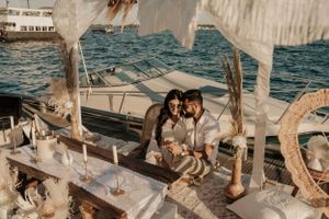 Intimate boat deck setup with candles, cushions and decorative elements on calm waters.