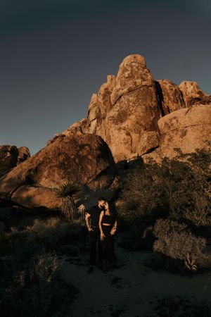 Silhouette of couple against majestic desert rock formations at dusk.