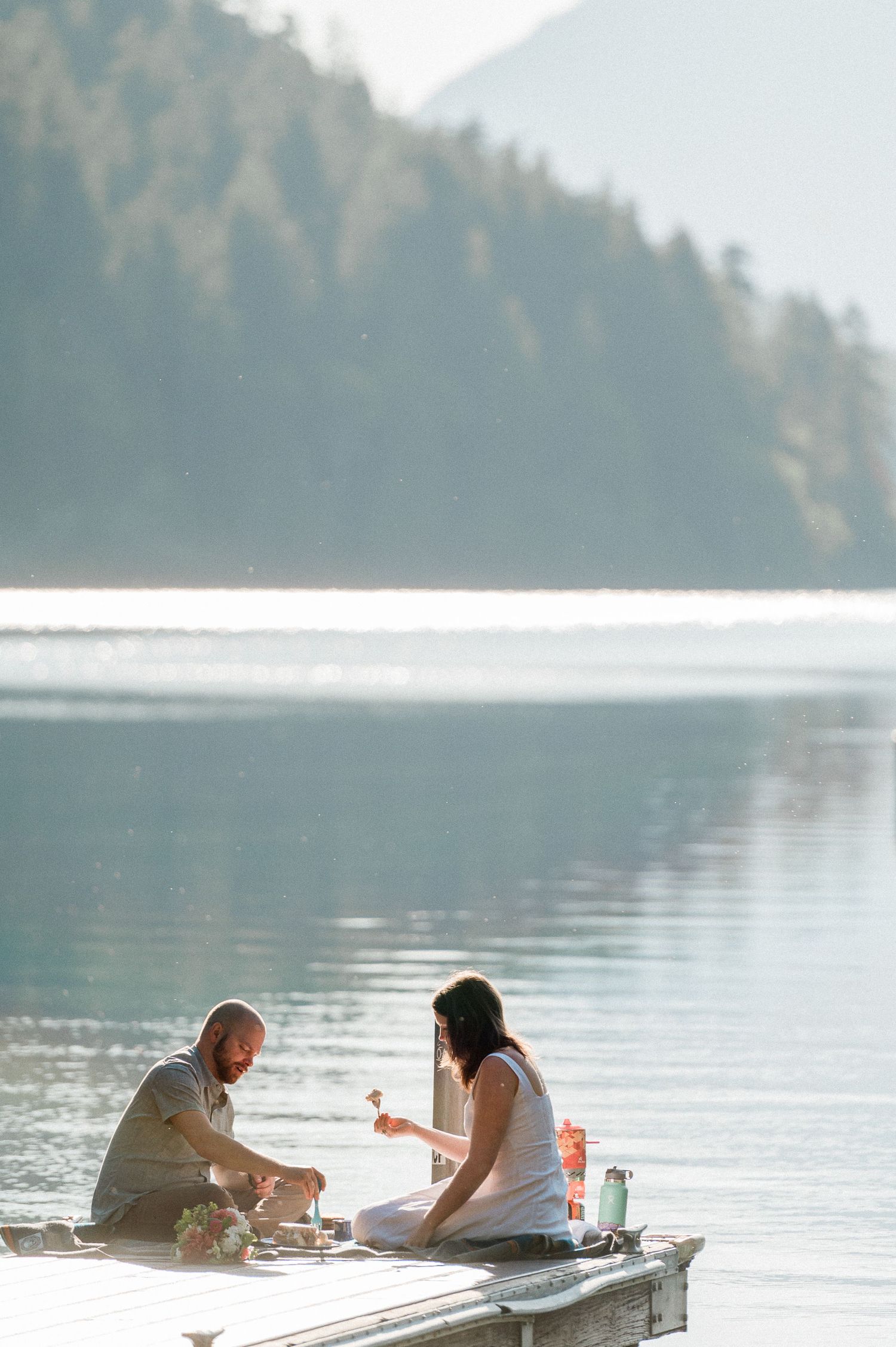 couple having breakfast sitting on dock