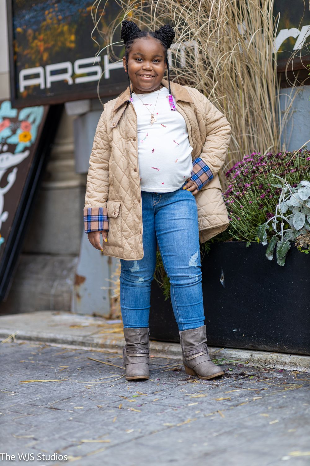 little girl in blue jeans, white shirt and tan coat