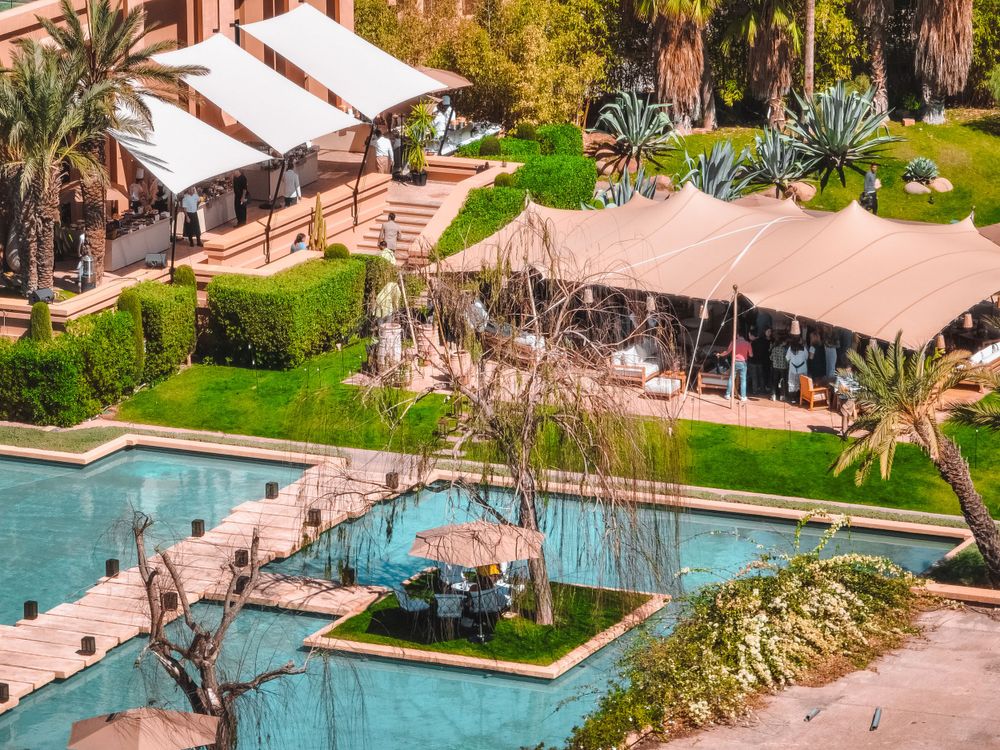 Luxury resort with swimming pools and palm trees viewed from above.