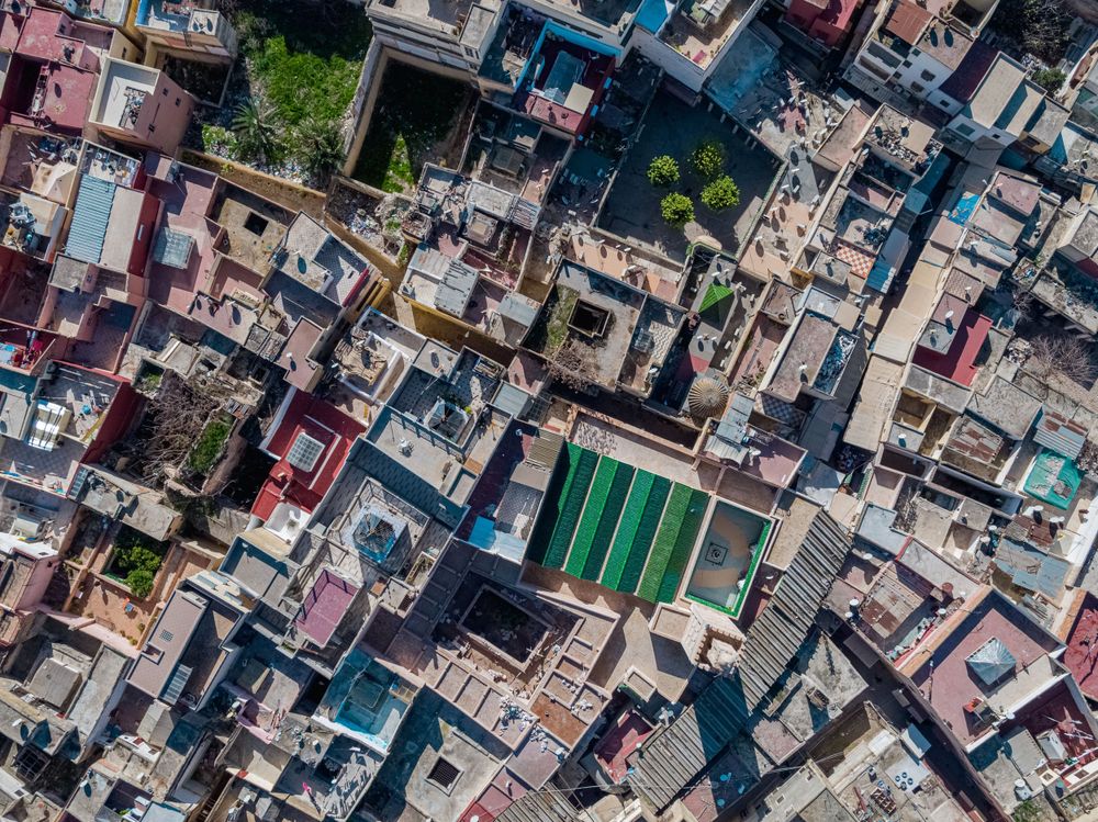 Bird's eye view of densely packed urban buildings with colorful rooftops.