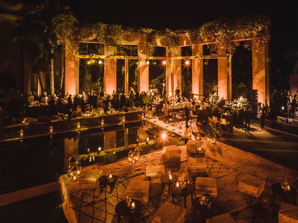 Romantic outdoor venue with illuminated columns and candlelit tables at night.