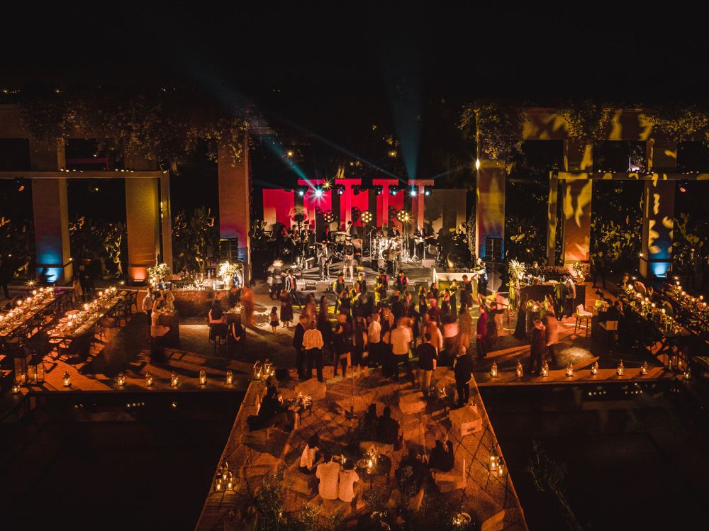 Elegant outdoor evening event space lit with warm ambient lighting and hanging decorations.