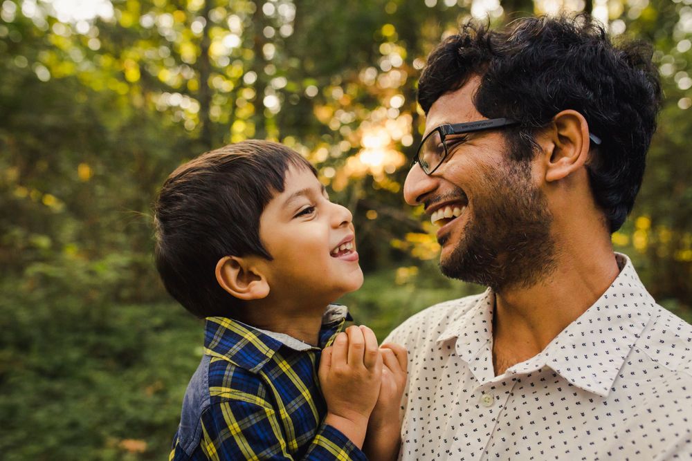 Father son laughing together at sunset in Bellevue Botanical Garden.