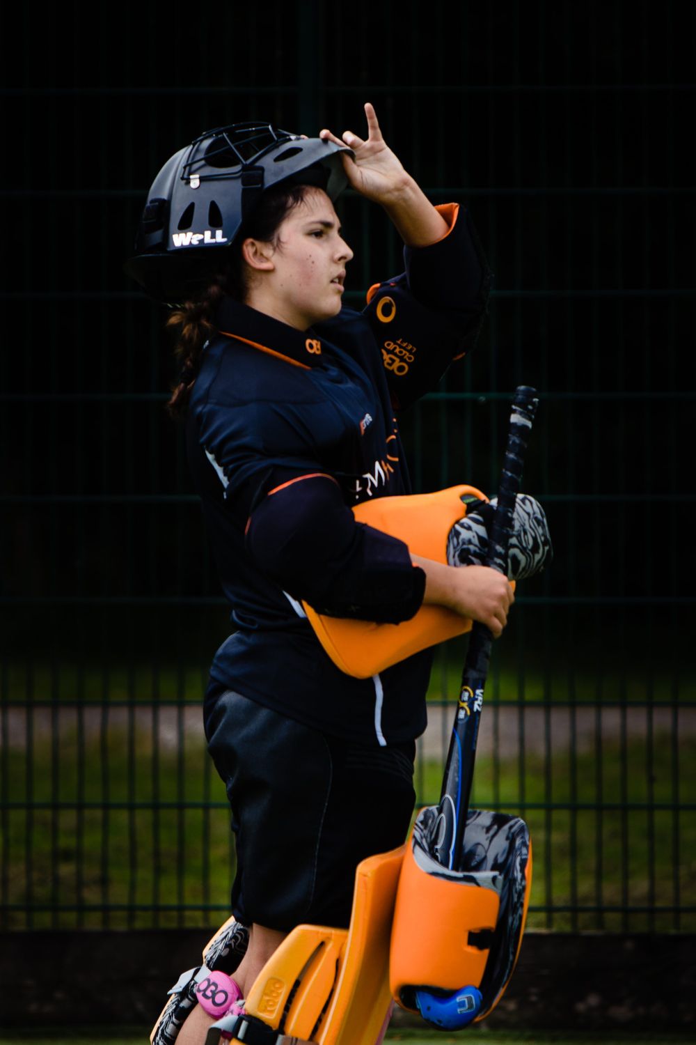 Field hockey goalkeeper adjusting helmet during training session
