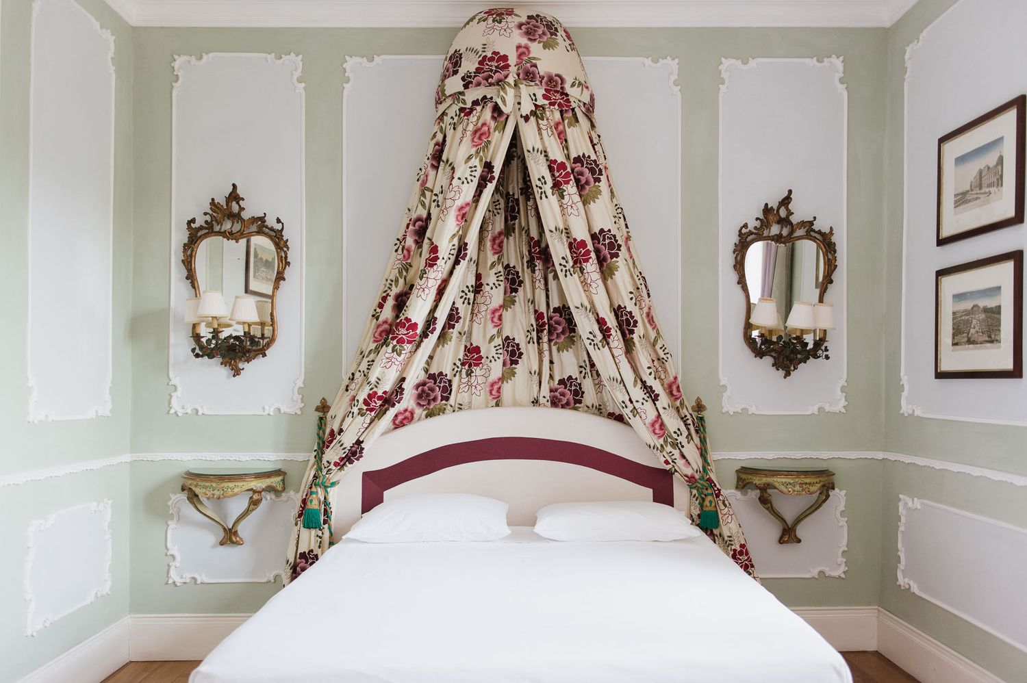 Luxurious bedroom with floral canopy bed and ornate gilded mirrors in a classic European style.