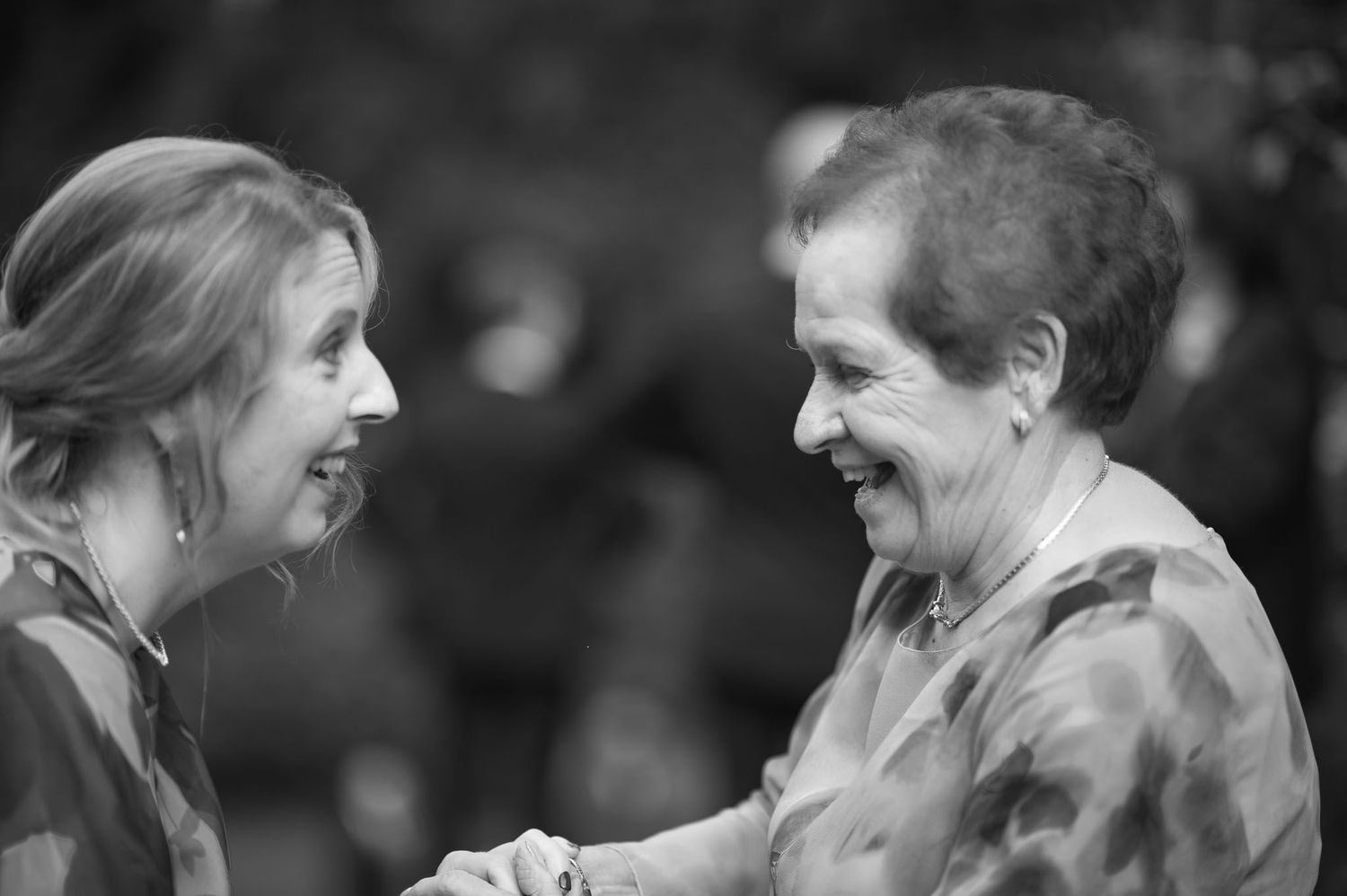 Two people sharing a joyful moment in black and white portrait.