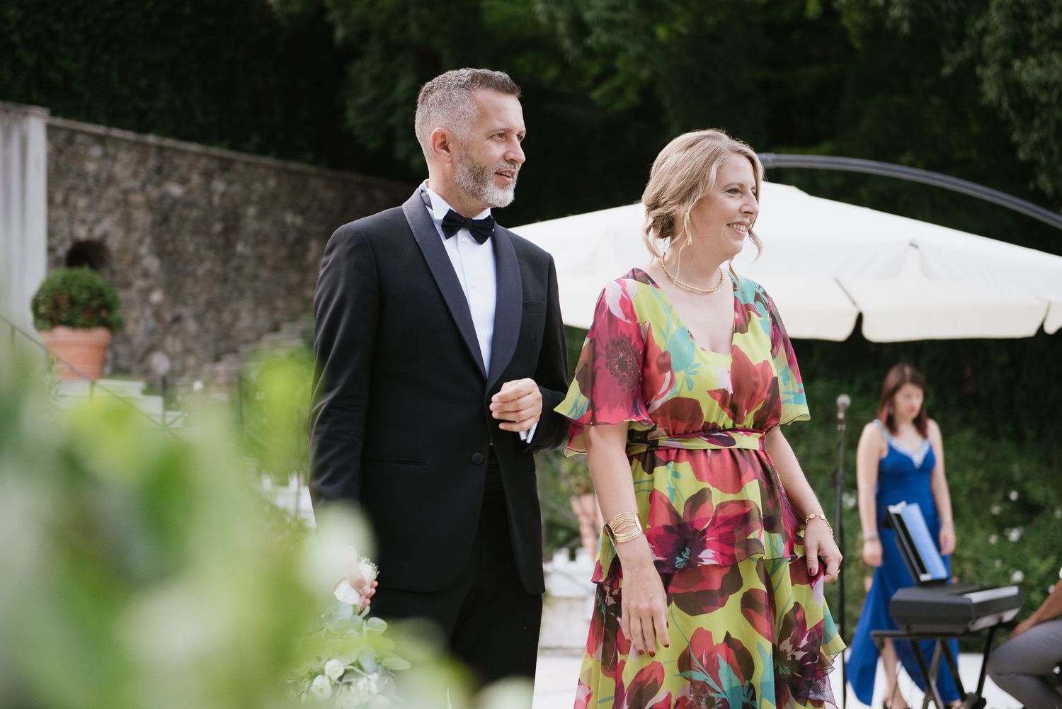 Couple walking together at outdoor garden wedding reception.