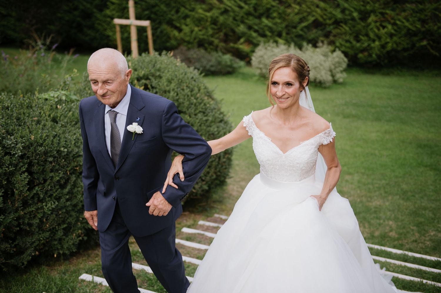 Walking down garden steps during an elegant outdoor wedding celebration.
