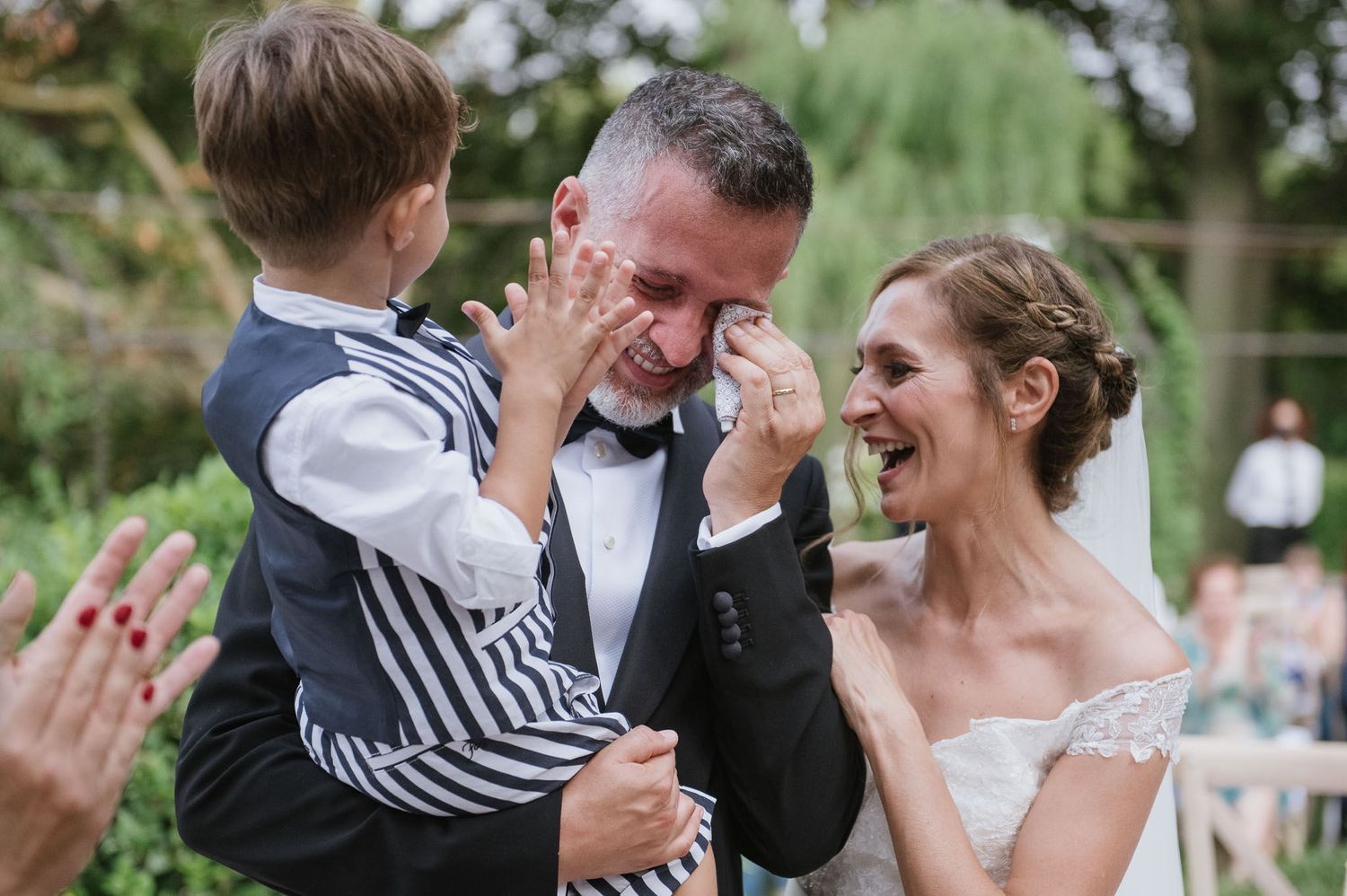 An intimate family moment captured during an outdoor wedding celebration.
