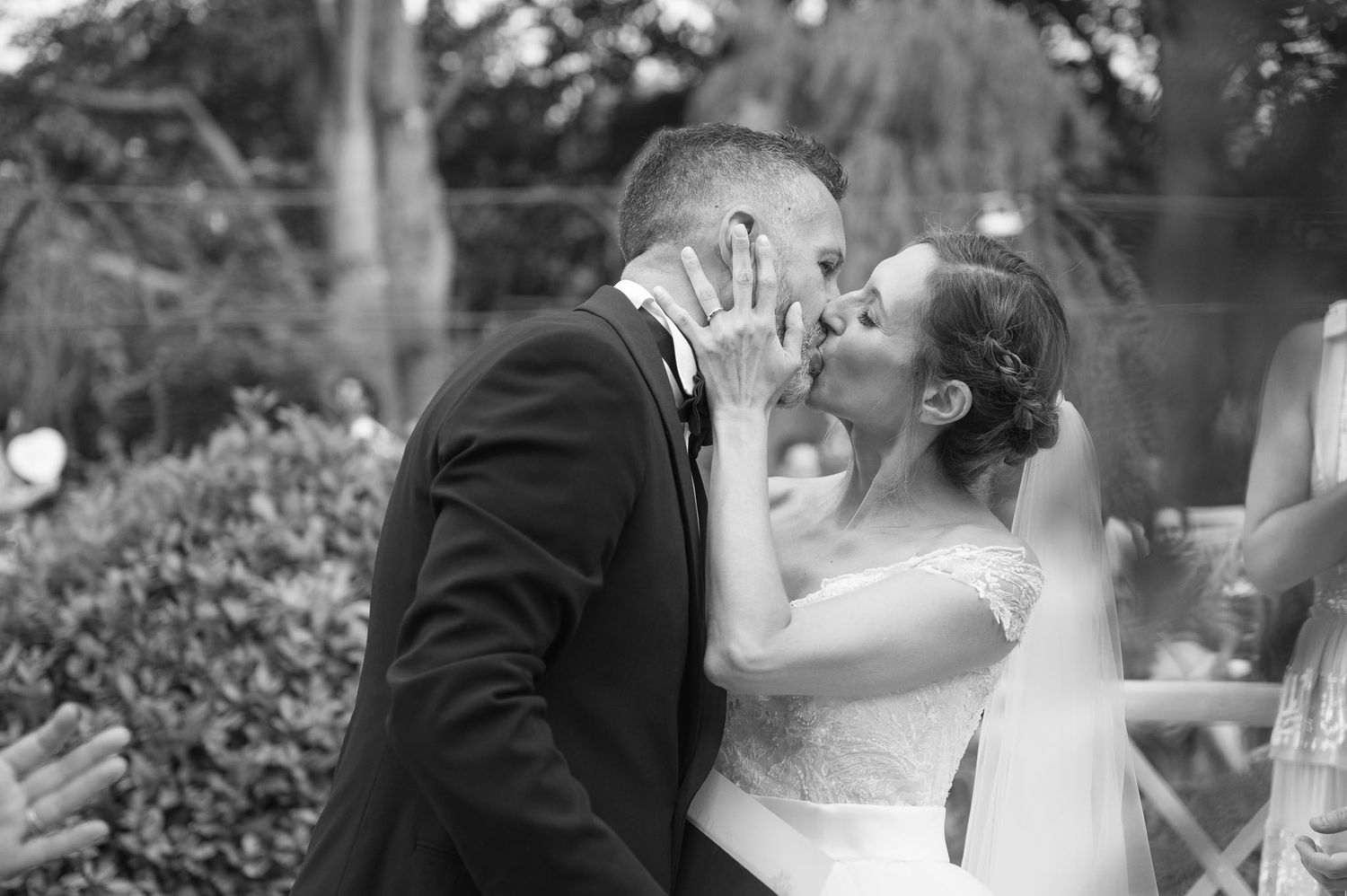 A romantic wedding photo on grand outdoor steps with cypress trees at sunset.