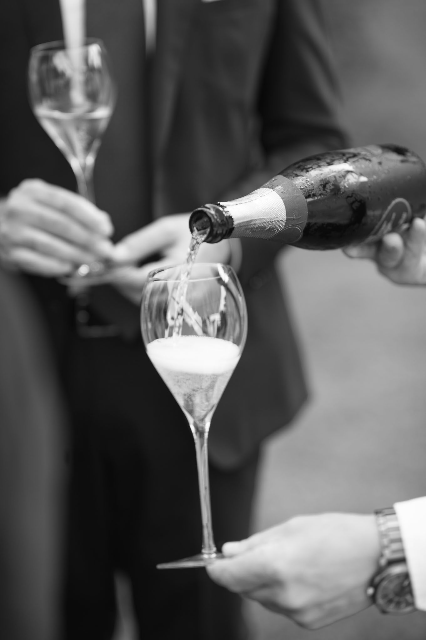 Elegantly pouring champagne into crystal flutes at a formal celebration.