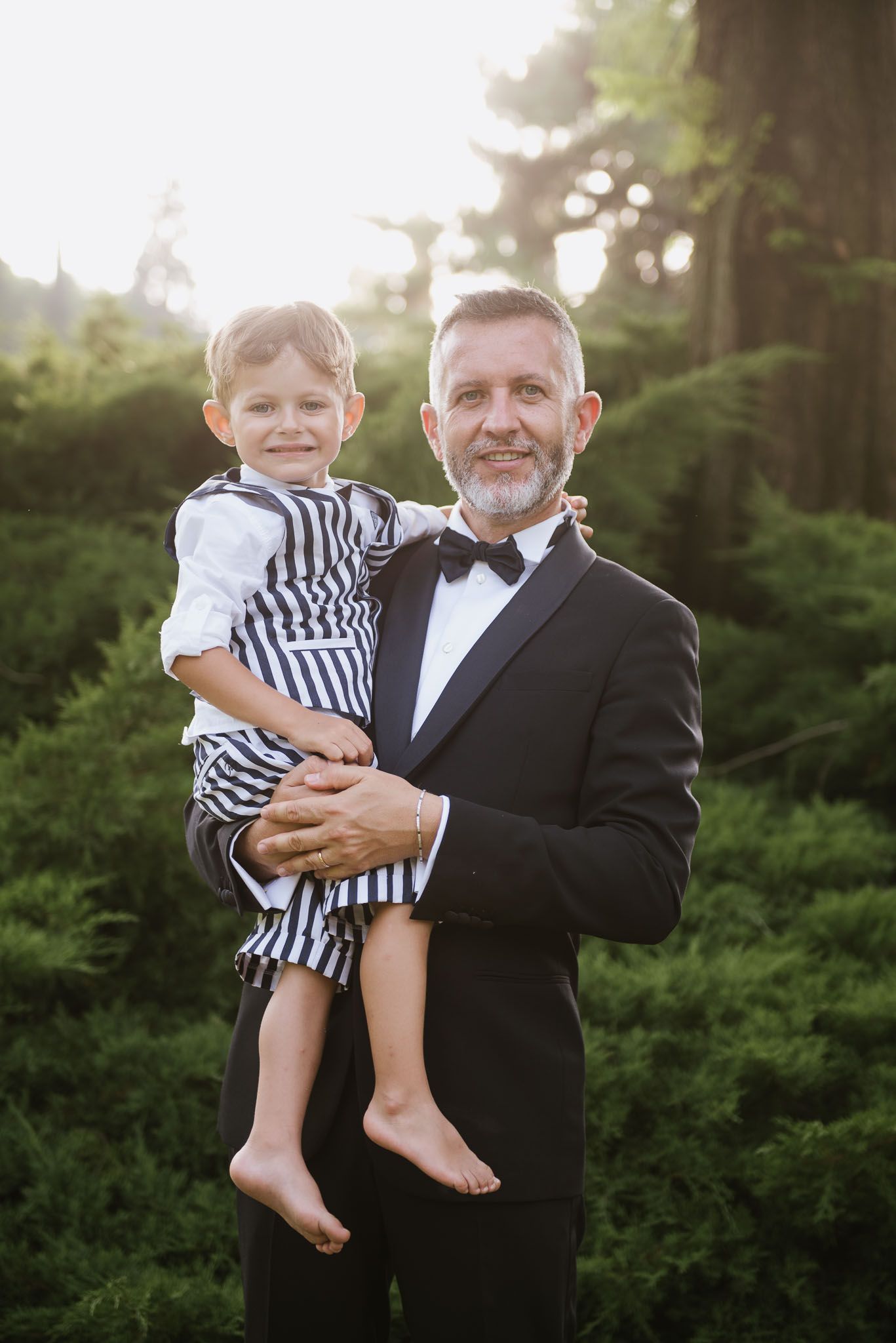 Formal portrait in garden setting with striped nautical outfit details.