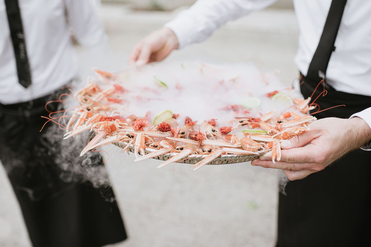 Hands holding pink confetti and sparklers against a dark background.