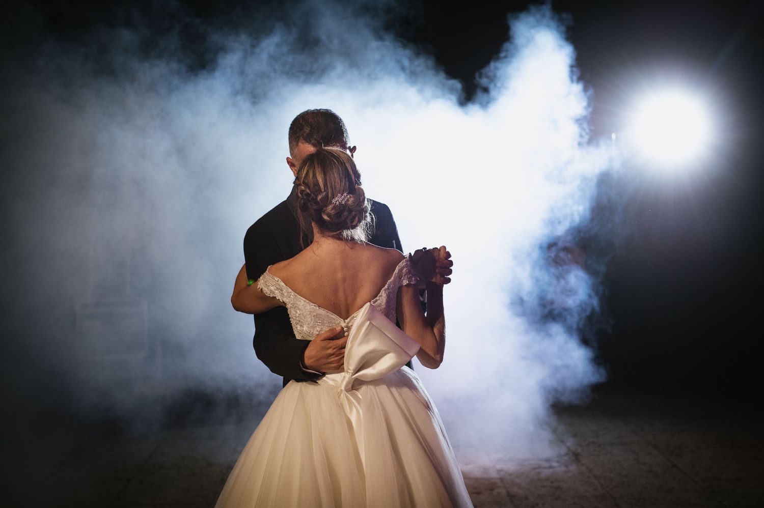 A romantic dance moment with smoke effects and dramatic backlighting.