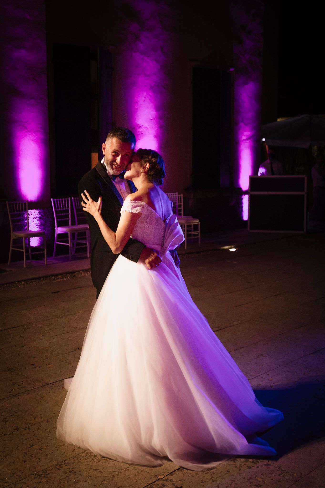A graceful wedding dance captured with purple ambient lighting.