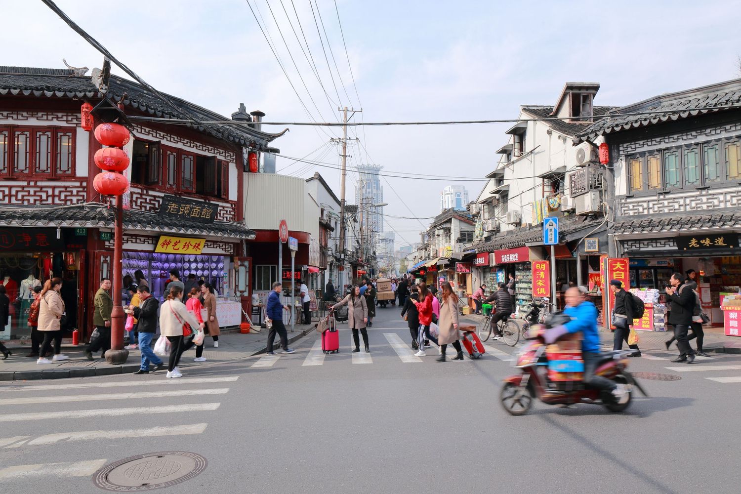 Busy street scene in Shanghai with traditional Chinese architecture and shops.