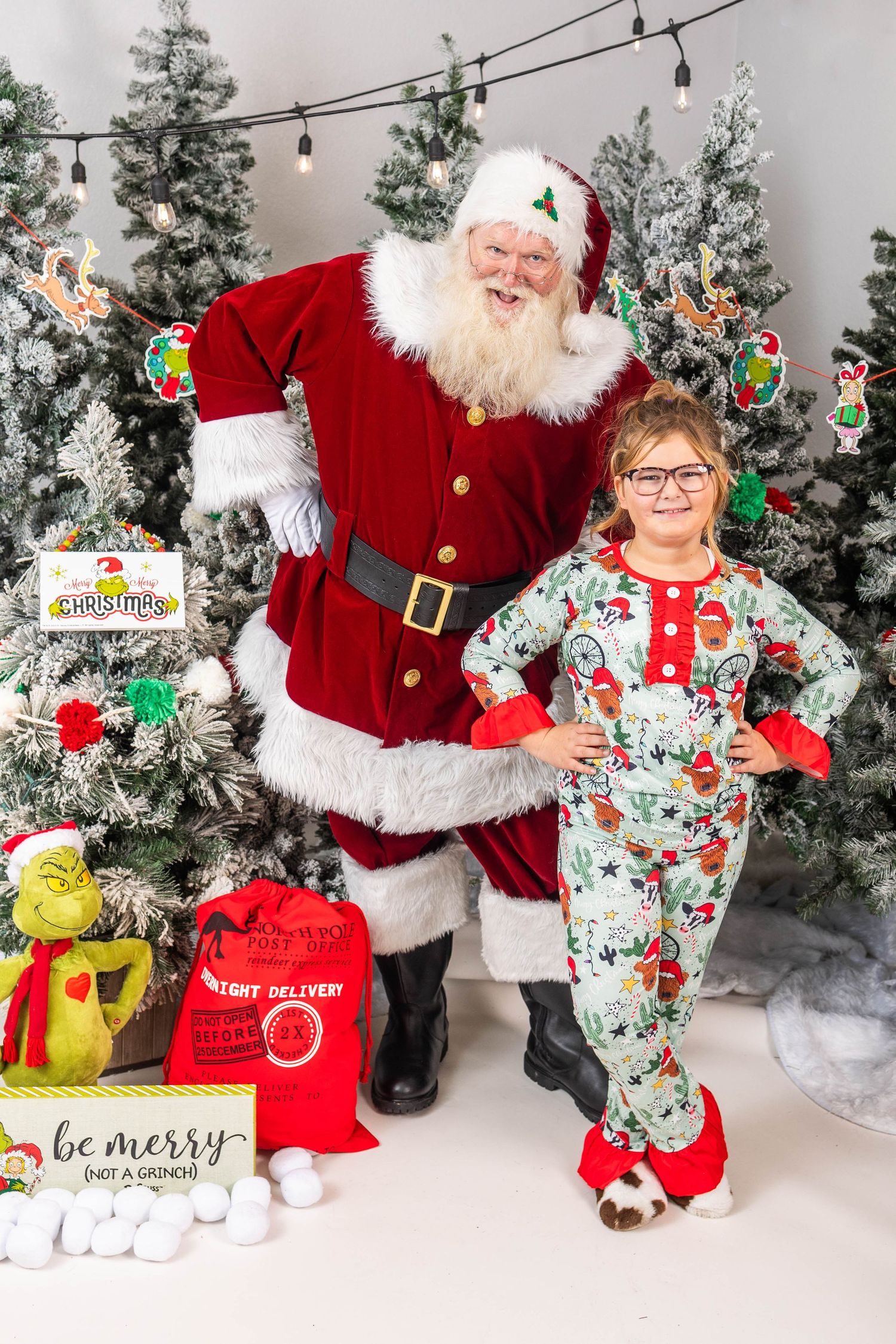 A festive Christmas scene with Santa Claus and a child in matching holiday pajamas.