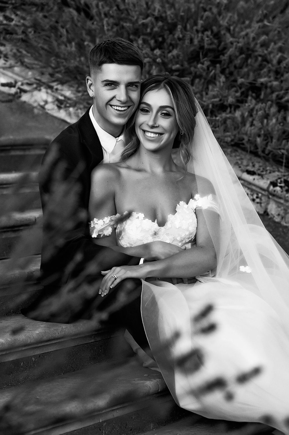 Black and white portrait of couple sharing intimate moment outdoors.